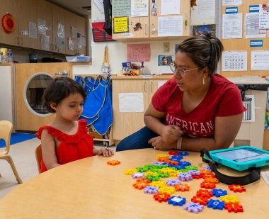 Teacher and child sitting at a table